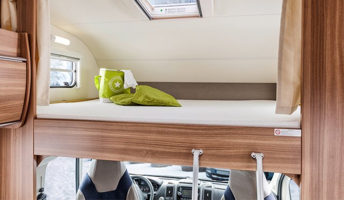 Het bed in de cab-over in de Grande camper van Bunk Campers 